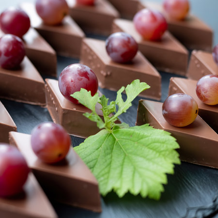 Small sliced triangle shape chocolate cakes topping with fresh red grapes ready for sale
