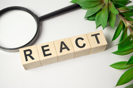 REACT - word of wooden blocks with a letter on white backgroundの写真素材