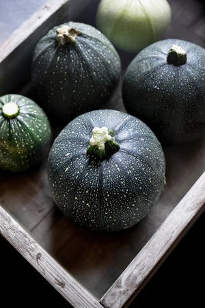 Organic round zucchini in wooden boxの写真素材