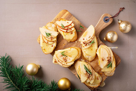 Pear and brie crostini with honey, pecan and rosemary, New Years Eve or Christmas party appetizerの写真素材