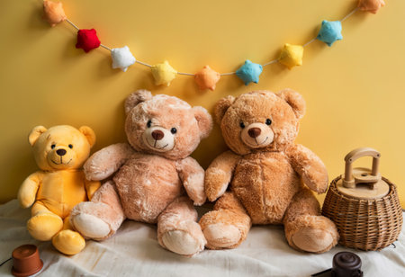 two cute brown teddy bears sitting on a yellow background, childrens toyの写真素材