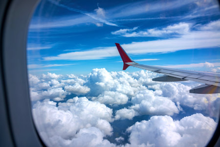 Beautiful view of Cloudscape and airplane wing seen through window of an airplane