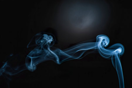 A captivating image showcases wispy, ethereal blue smoke swirling and flowing against a stark black...