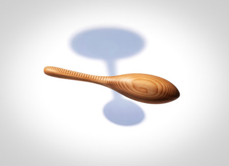 A single, light-colored wooden spoon is presented against a clean white background. The spoon features a smooth, oval bowl and a handle with delicate parallel grooves.の写真素材