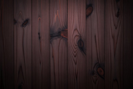 A close-up, top-down view of vertical dark brown wooden planks. The surface features prominent natural knots and visible wood grain patterns, creating a rustic and textured background.の写真素材