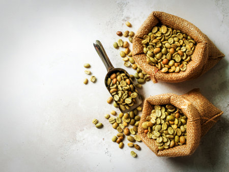 Green and brown decaf unroasted coffee beans in hemp sack bags with scoops setupの写真素材