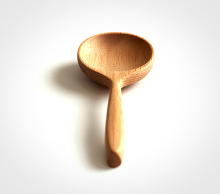 A single, light-colored wooden spoon is presented against a clean white background, showcasing its natural grain and gently curved handle.の写真素材