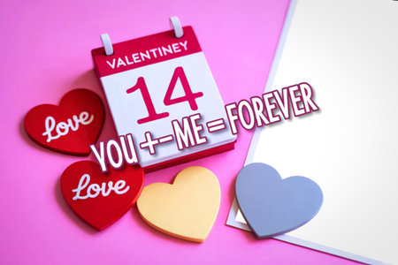 A festive arrangement for Valentine's Day featuring a calendar marking the 14th, hearts, and the phrase "You plus me equals forever."の写真素材