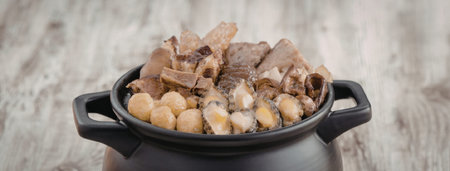A black bowl filled with a variety of ingredients on a wooden surfaceの写真素材
