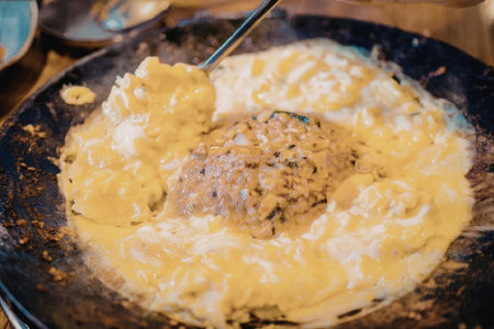 a cheesy dish with a meatball in the center on a panの写真素材