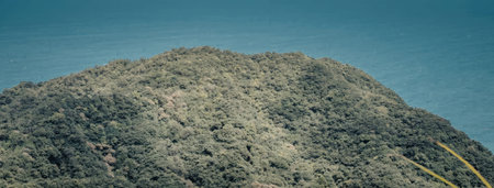 A serene landscape of a lush green mountain set against a clear blue sky