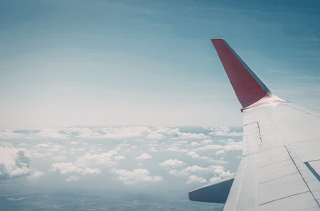 A view of an airplane wing flying above the clouds on a clear day.
