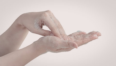 a pair of hands applying cream on dry skin