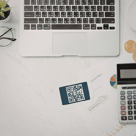 A workspace with a laptop, calculator, and financial tools on a white desk.