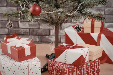 a group of wrapped christmas presents under a decorated tree