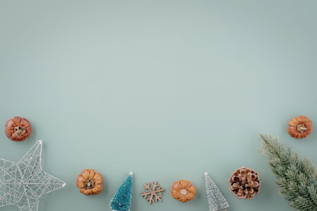A festive arrangement of Christmas decorations on a light blue background, featuring a star, trees,...