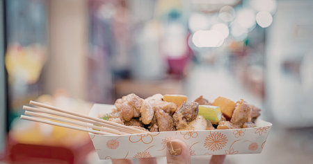 A close-up shot of a paper container filled with food and a pair of chopsticksの写真素材