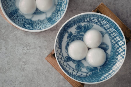 An overhead shot of two blue and white bowls containing tangyuan, a traditional Asian dessert made...
