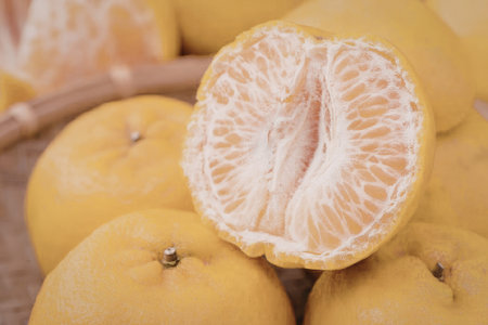 A close-up of fresh oranges with one cut open, revealing its juicy interior.