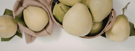 A photo of green pears in and out of a brown bag on a white background