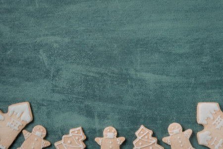 A row of gingerbread cookies on a green background