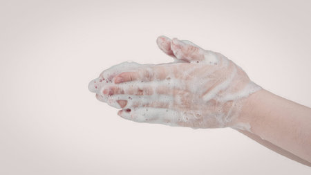 A hand covered in soap, demonstrating the action of washing hands.