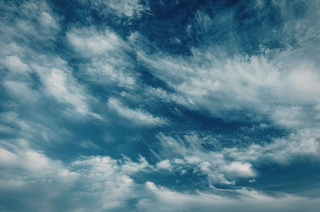 A clear blue sky with scattered white clouds