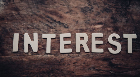 A close-up of wooden surface with the word 'INTEREST' in white lettersの写真素材