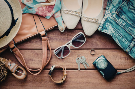 A collection of summer vacation essentials including a hat, bag, shoes, sunglasses, and accessories...