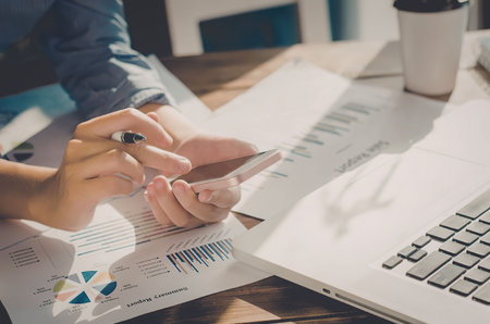 A person analyzing business data with documents and graphs