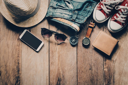A collection of summer vacation essentials including a hat, sunglasses, phone, watch, wallet, shoes,...