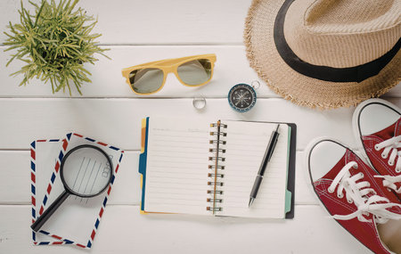 A collection of items needed for planning a summer vacation, including a notebook, pen, sunglasses,...