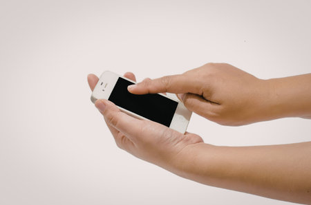 A person's hand holding a white smartphone with a blank screen.