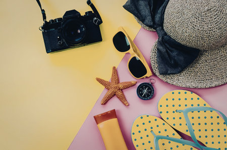 A colorful arrangement of summer vacation essentials including a straw hat, sunglasses, starfish,...