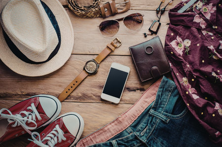 A collection of summer vacation essentials including a hat, headphones, phone, glasses, sneakers,...