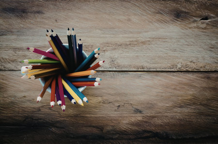 A bunch of colorful pencils on a wooden surface
