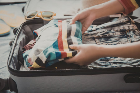 a person packing clothes into a suitcase