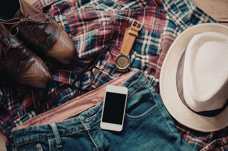 A stylish arrangement of country outfit accessories including a plaid shirt, denim jeans, leather...