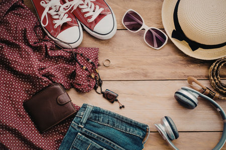 A flat lay of summer clothing and accessories on a wooden backgroundの写真素材