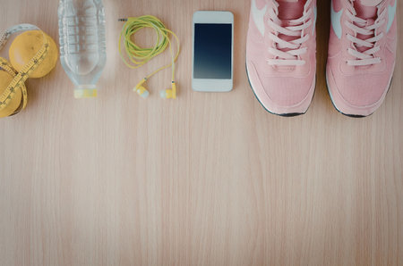 A collection of fitness essentials including a water bottle, measuring tape, earbuds, smartphone,...