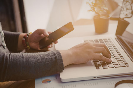A person is sitting at a desk, using a laptop and holding a credit card.