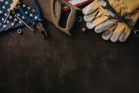 A selection of tools and a glove on a dark surface