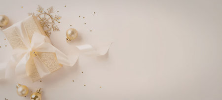 A beautiful arrangement of gold ornaments and a ribbon on a beige backgroundの写真素材