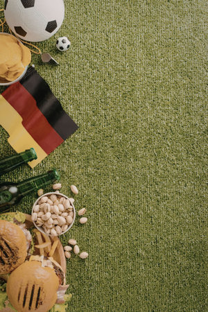 A collection of German snacks and football items on a green fieldの写真素材