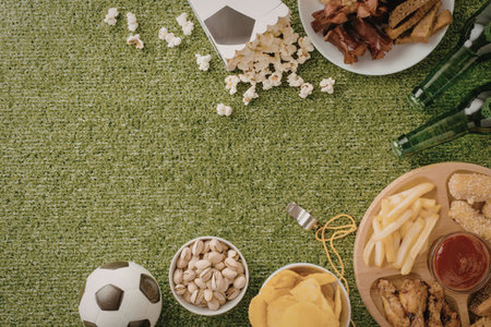 An overhead shot of a football party spread with snacks and food on a green turf backgroundの写真素材