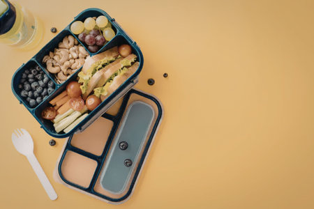 A lunch box filled with healthy food on a yellow background