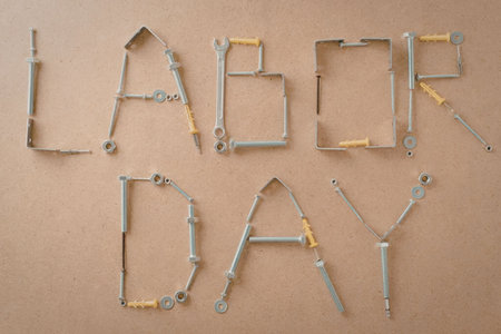A creative representation of Labor Day using tools to form the words 'Labor Day' on a brown...