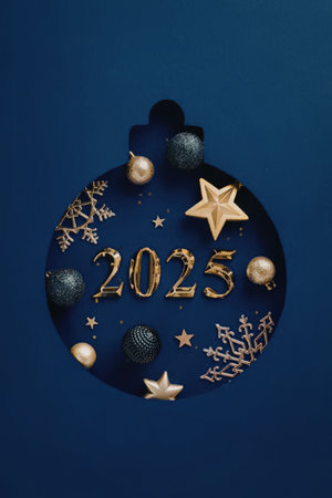 A blue and gold Christmas ornament with 2025 written in the center, surrounded by stars, snowflakes,...