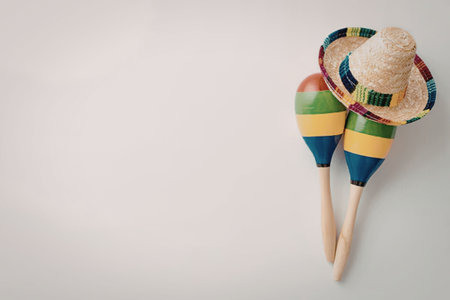 A colorful still life featuring a sombrero and maracas against a plain background