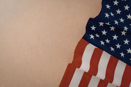 A portion of the American flag with red and white stripes and blue field of white stars on a beige...